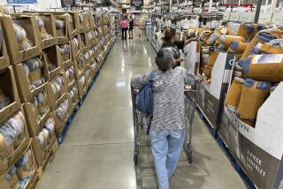 File - Shoppers look over blankets on sale in a Costco warehouse on Aug. 24, 2023, in Sheridan, Colo. On Thursday, the Commerce Department issues its first of three estimates of how the U.S. economy performed in the third quarter of 2023. (AP Photo/David Zalubowski, File)