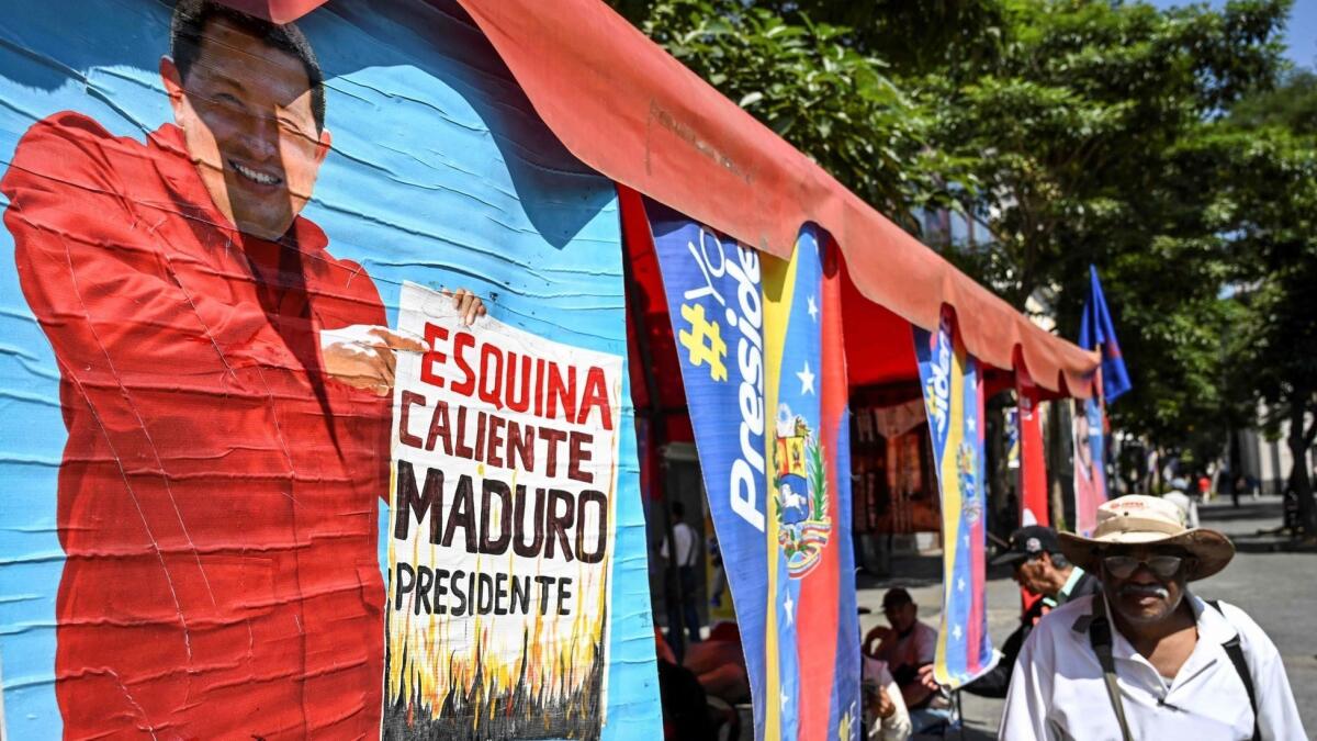 A man walks past a painting depicting late Venezuelan President Hugo Chavez in Caracas on Friday.