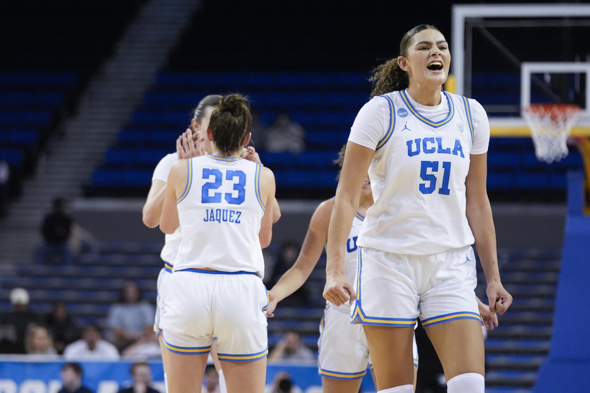 加州大学洛杉矶分校 (UCLA) 中锋劳伦·贝茨 (Lauren Betts) 一边大喊，一边将拳头放在身体两侧，旁边的队友则高举五杆。