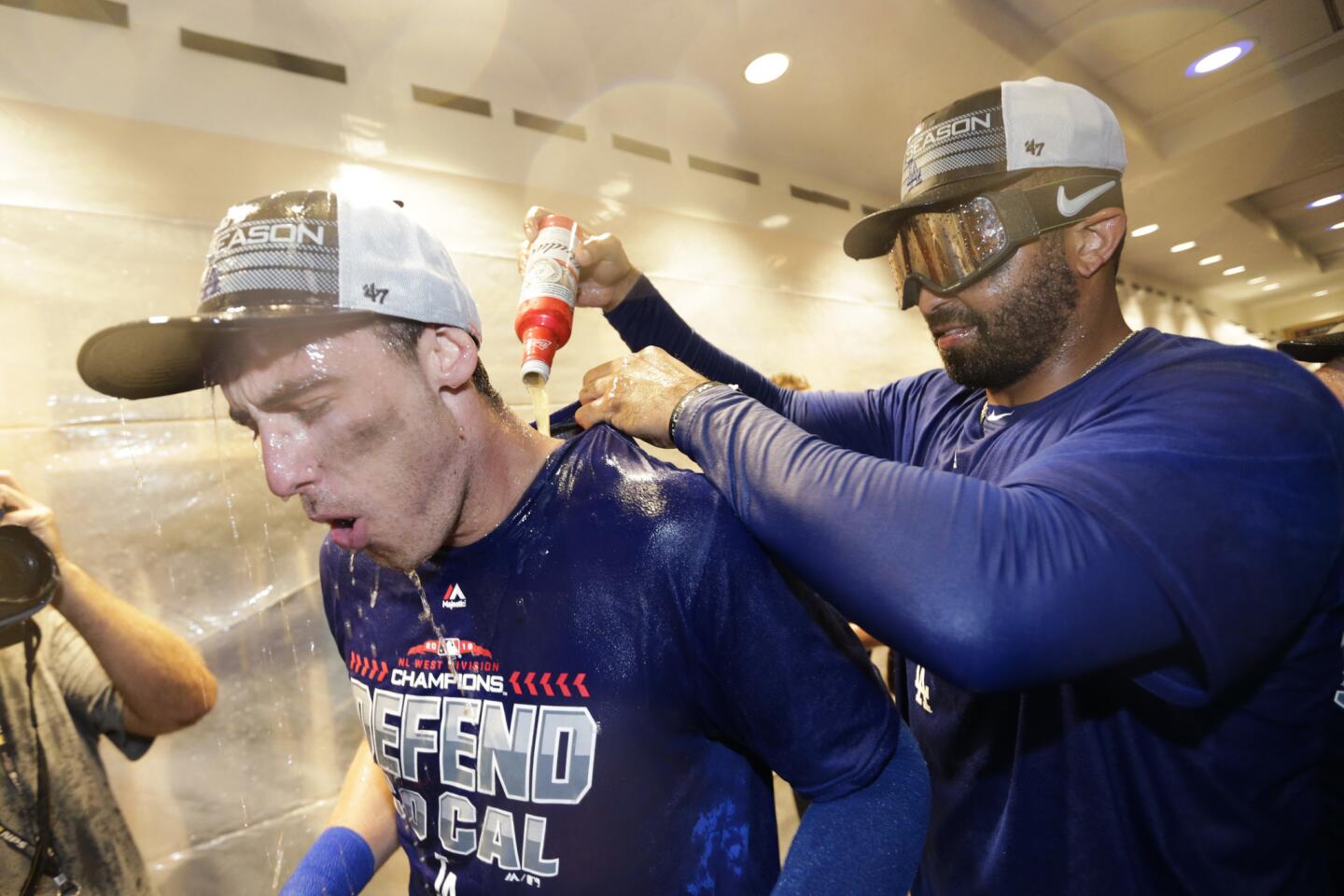 Los Angeles Dodgers' Matt Kemp, left, pours beer on Cody Bellinger while celebrating in the clubhouse after the team's 5-2 win against the Colorado Rockies in a tiebreaker baseball game, Monday, Oct. 1, 2018, in Los Angeles. (AP Photo/Jae C. Hong)