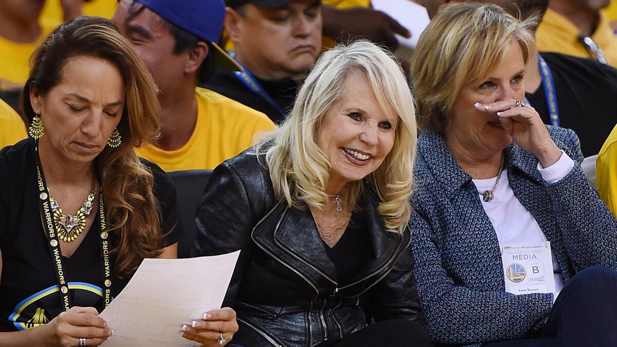 Shelly Sterling, center, laughs while sitting courtside during a playoff game between the Clippers and the Golden State Warriors in April 2014.