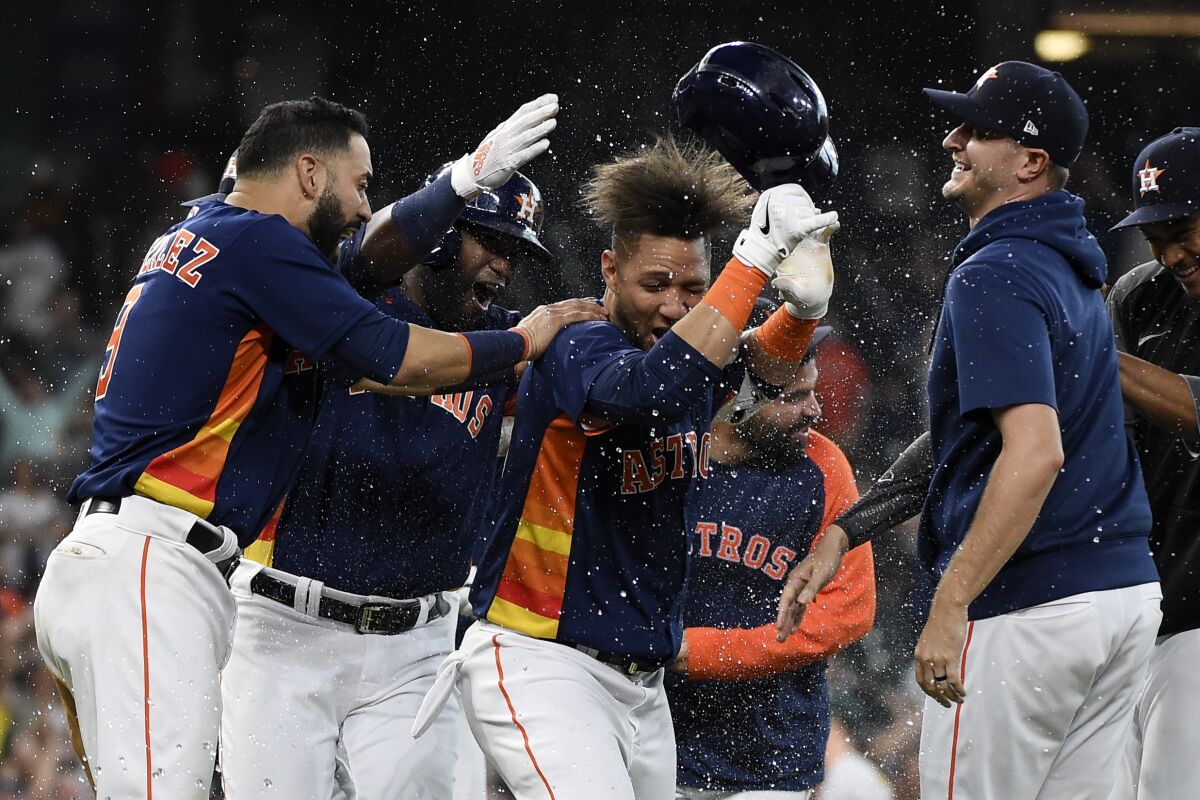 Houston Astros' Yuli Gurriel, center, celebrates his winning hit during the ninth inning of a baseball game against the Oakland Athletics, Sunday, Oct. 3, 2021, in Houston. (AP Photo/Eric Christian Smith)