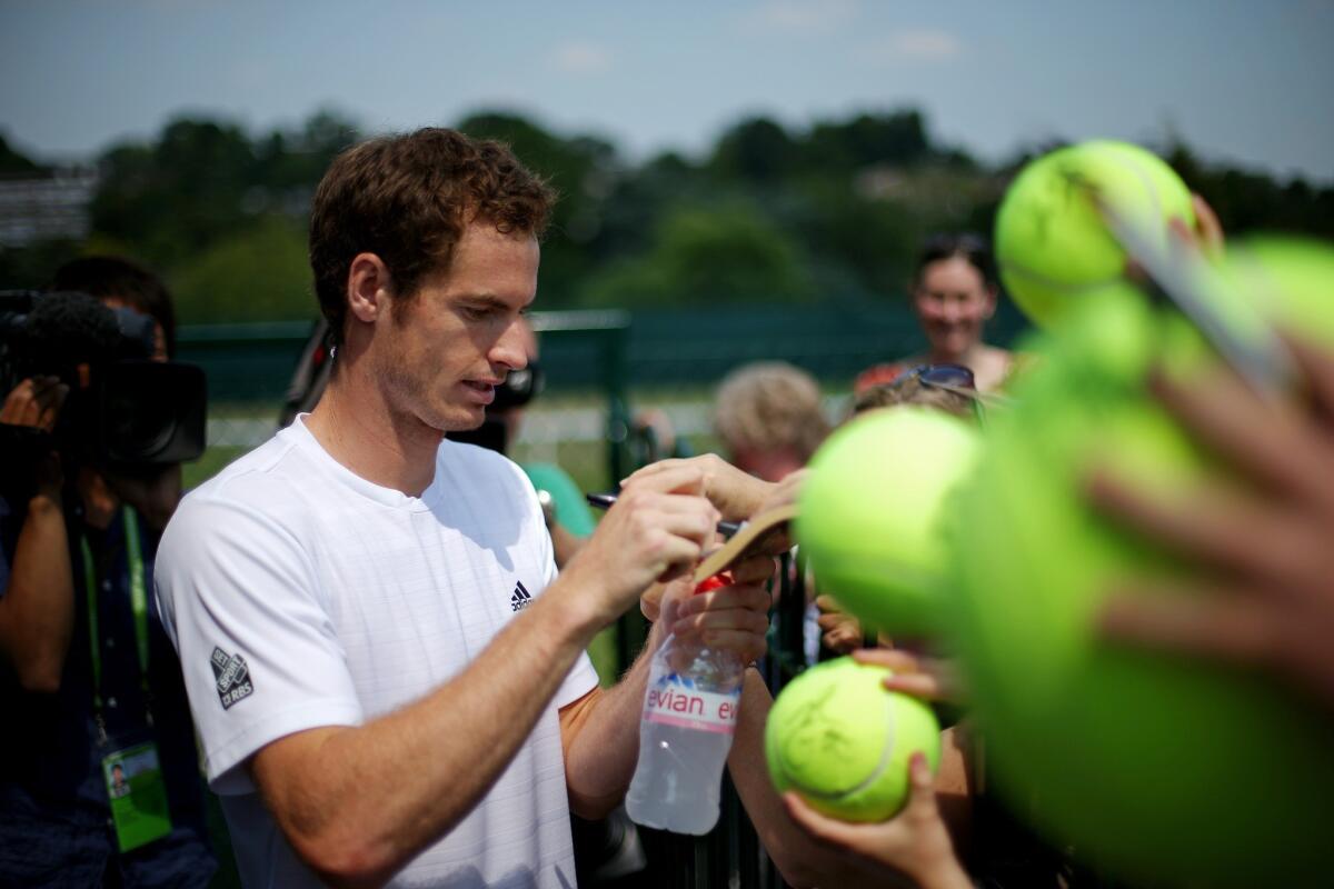 Andy Murray signs autographs for fans after a practice session at Wimbledon on Saturday.