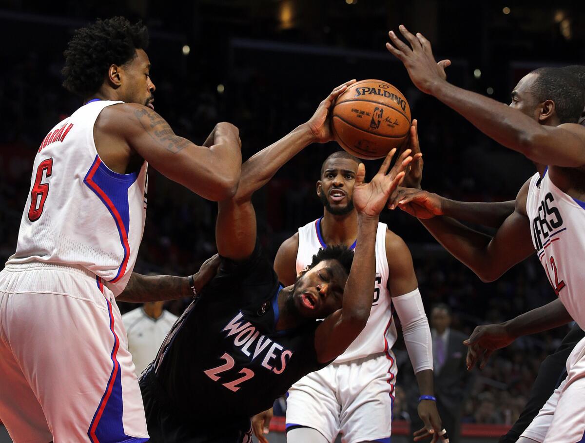 Timberwolves forward Andrew Wiggins loses his balance as he's surrounded by Clippers defenders Sunday.
