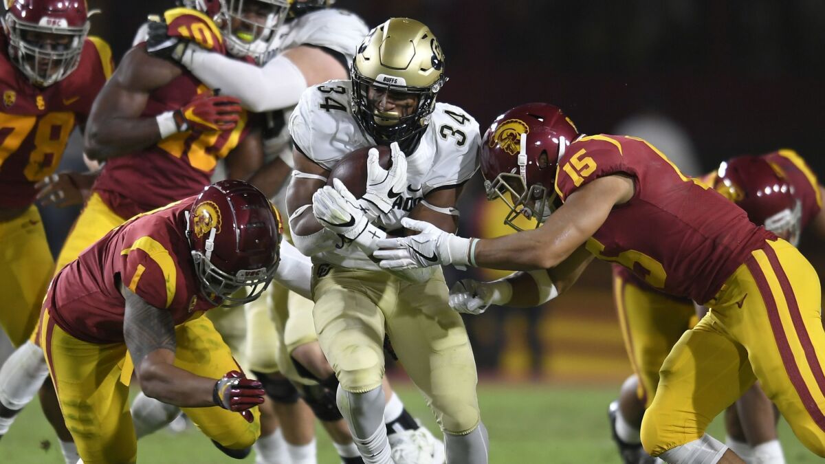 Running back Travon McMillian of the Colorado Buffaloes runs the ball into Palaie Gaoteote (1) and Talanoa Hufanga (15) USC in the second quarter.