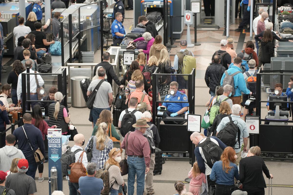 Numerosos viajeros hacen fila en un punto de revisión en la principal terminal del Aeropuerto Internacional de Denver