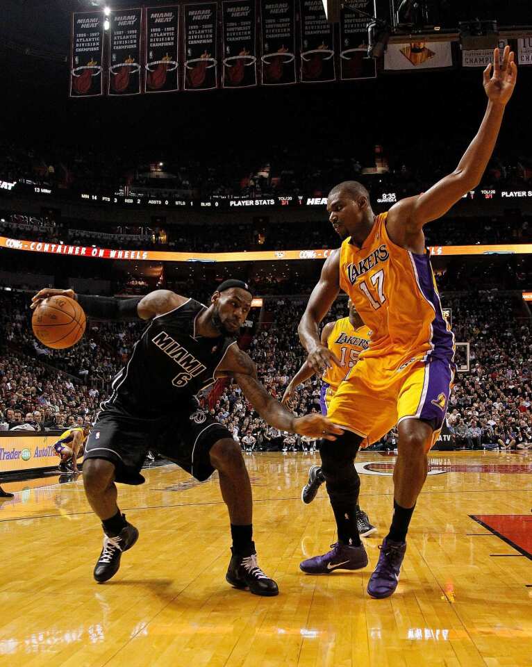 Heat forward LeBron James looks for room to get off a shot against the defense of Lakers center Andrew Bynum during their game Thursday night at American Airlines Arena in Miami. James scored 31 points in Miami's 98-87 victory.
