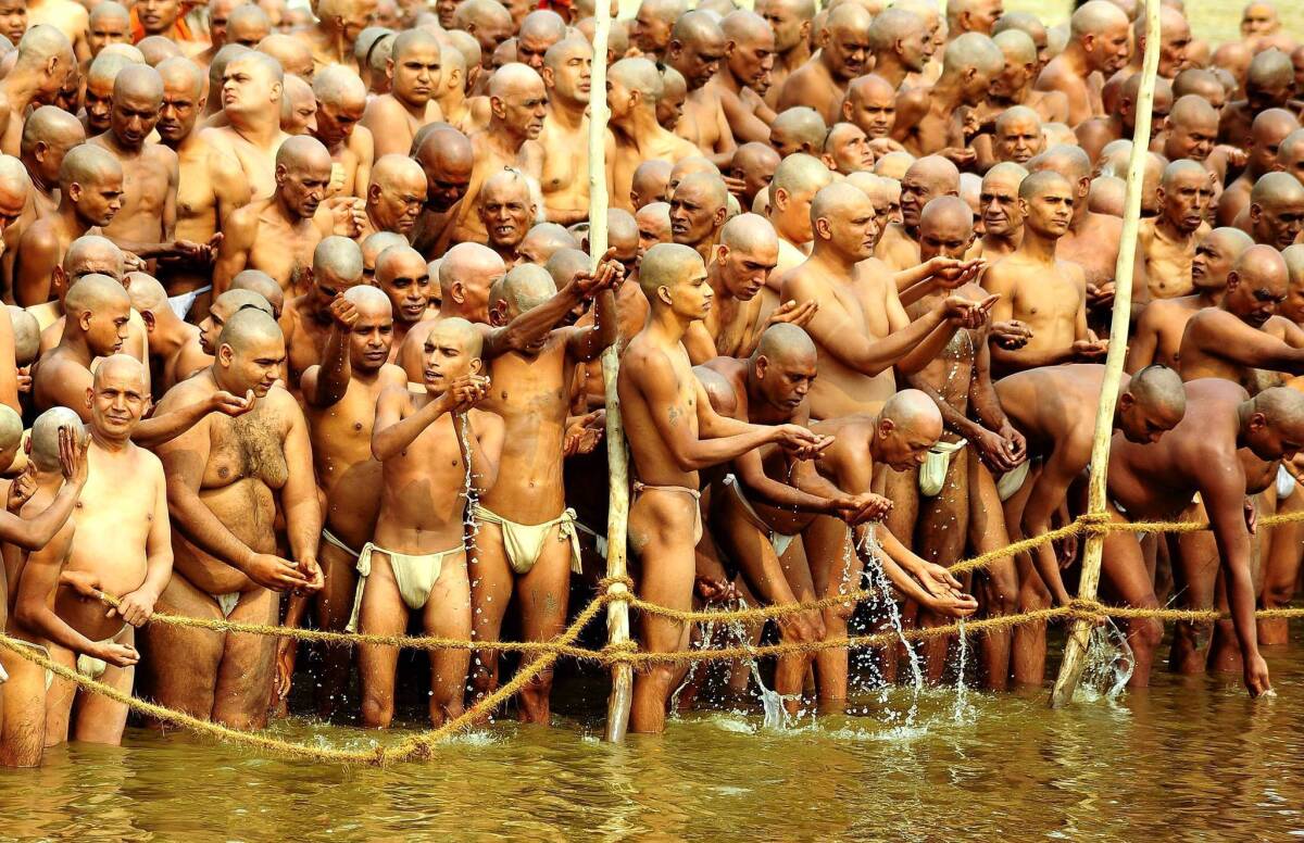 Newly initiated sadhus, or Hindu holy men, take a ritual dip in the Ganges River in Allahabad, India. The Maha Kumbh Mela religious festival is expected to draw 100 million people over 55 days.