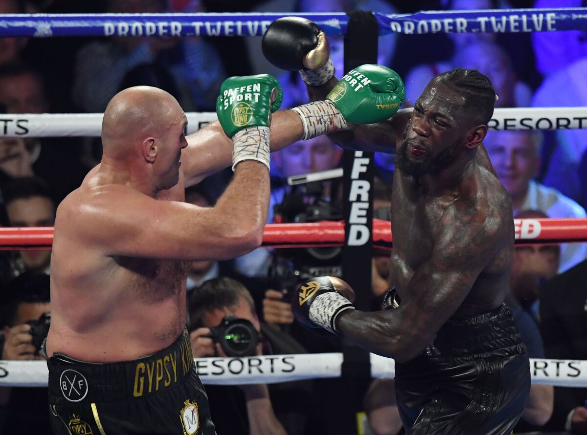 Tyson Fury, left, and Deontay Wilder exchange punches during their heavyweight title fight in Las Vegas on Feb. 22.