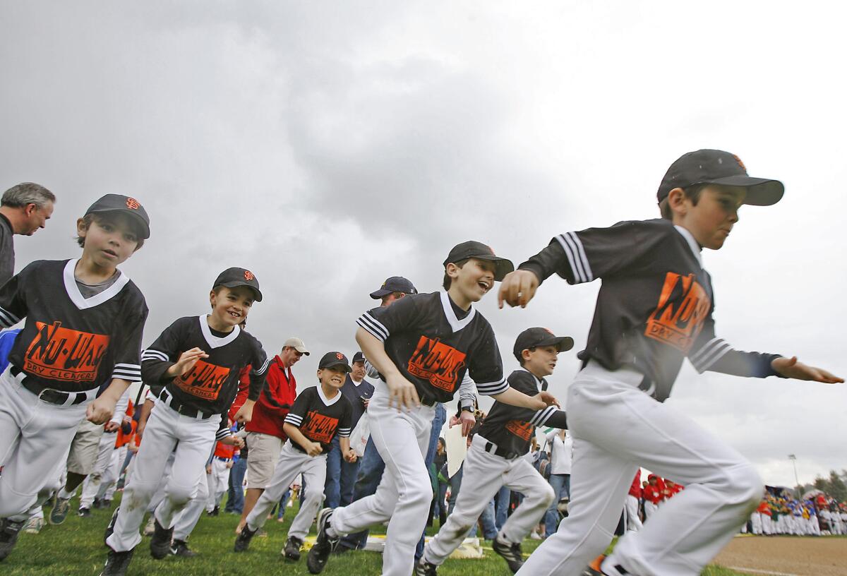Members of a team run around the field during the La Cañada Junior Baseball Softball Assn.'s opening day at La Cañada High School on March 7, 2010.