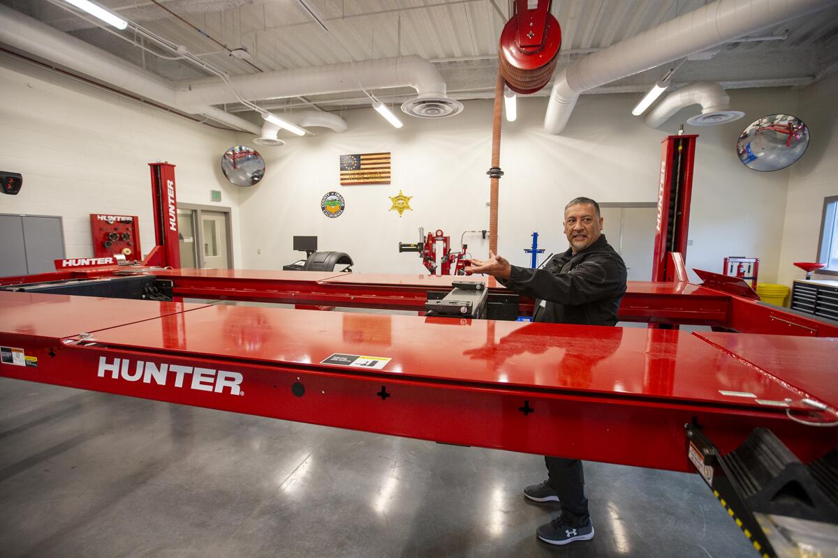 German Zarate, a deputy juvenile correctional officer, shows off the new auto shop.