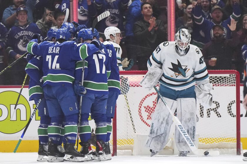 Vancouver Canucks' Anthony Beauvillier, from left to right, Ethan Bear, Elias Pettersson, Filip Hronek and Andrei Kuzmenko celebrate Kuzmenko's goal against San Jose Sharks goalie James Reimer during the first period of an NHL hockey game in Vancouver, British Columbia, Thursday, March 23, 2023. (Darryl Dyck/The Canadian Press via AP)