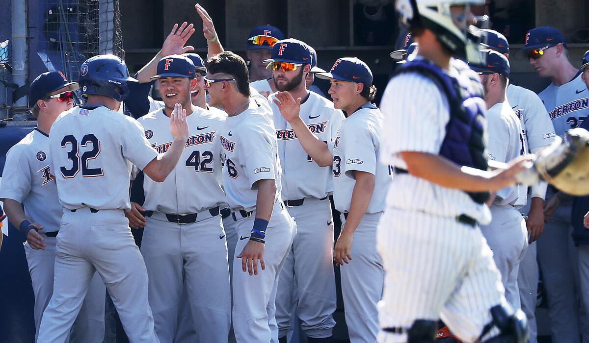 Cal State Fullerton's Jairus Rucahrds (32) is congratulated by teammates after scoring a run against Washington in the fifth inning of an NCAA college baseball tournament super regional game on June 9, 2018, at Goodwin Field in Fullerton.