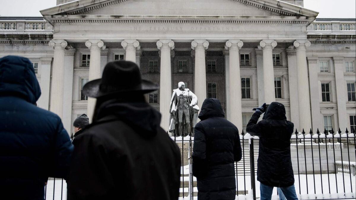 People walk past the Treasury Department building in Washington on Jan. 13.