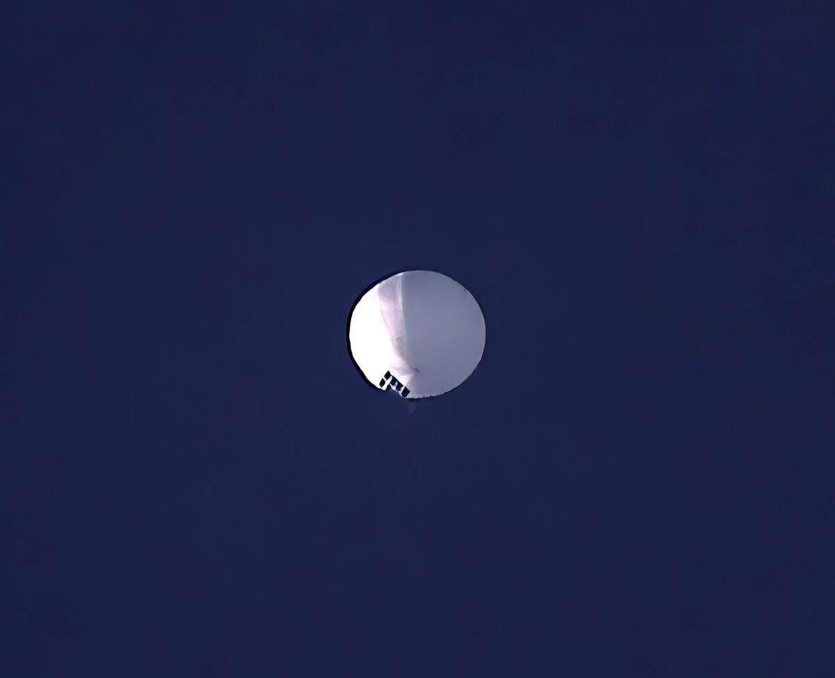 High-altitude white balloon against a blue sky