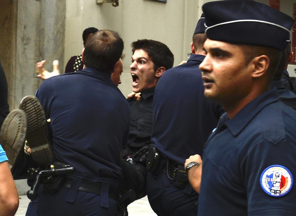An animal rights activist is carried away by policemen after staging a protest outside Fendi's haute couture show on Wednesday.