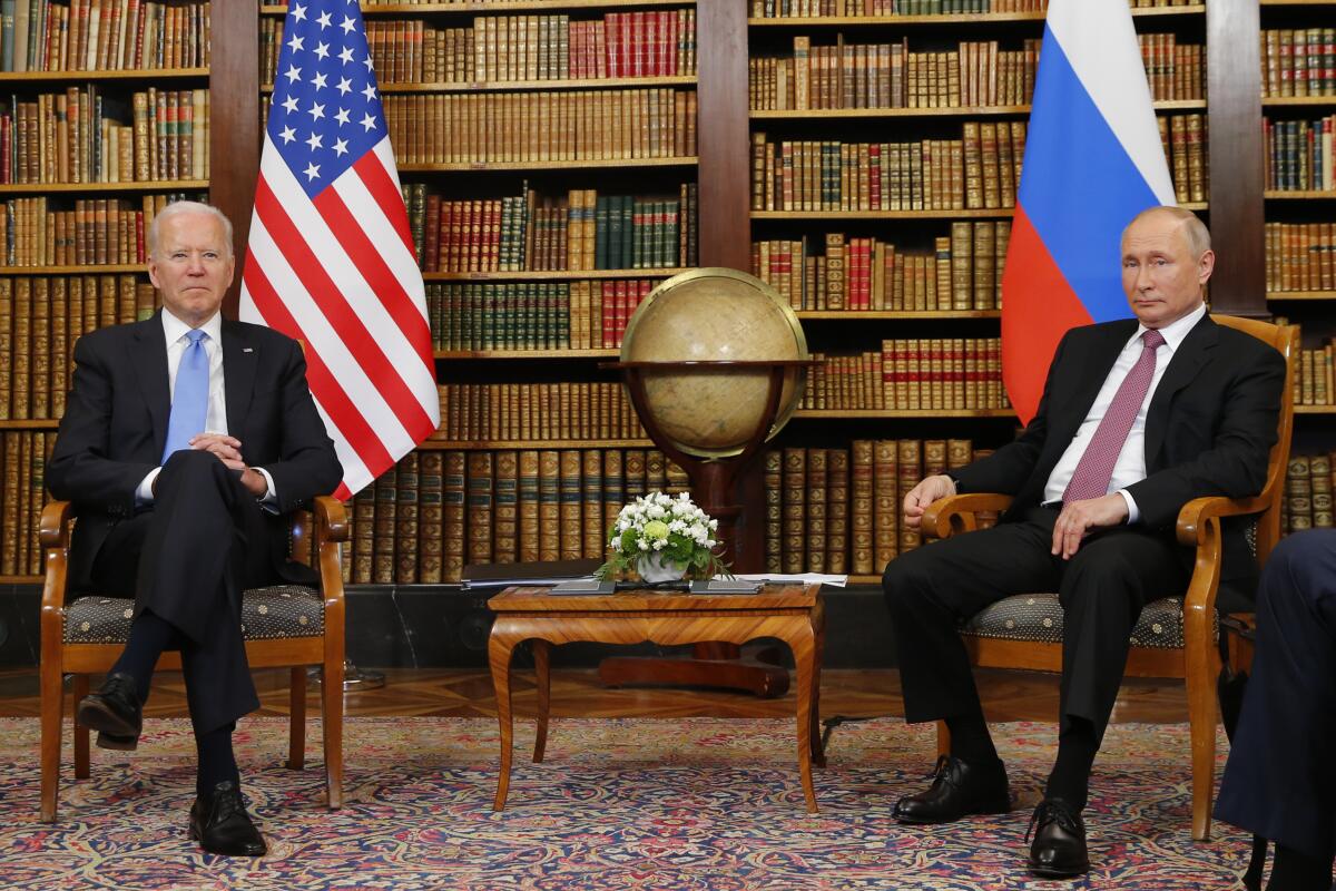 President Biden and Russian President Vladimir Putin sit in socially distanced chairs. 