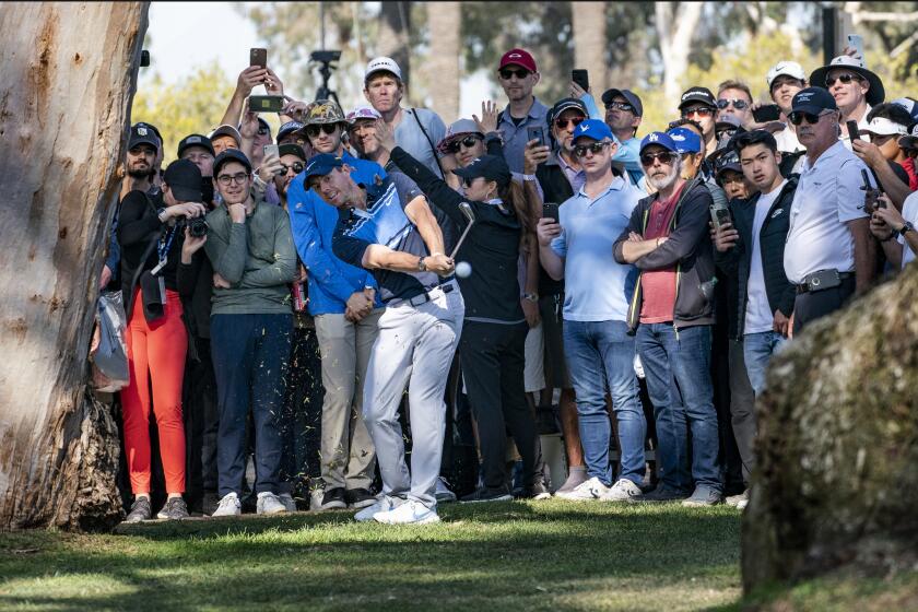 Rory McIlroy attempts a shot between trees from the rough at No. 13 during the final round of the Genesis Invitational at Riviera Country Club on Feb. 16, 2020.