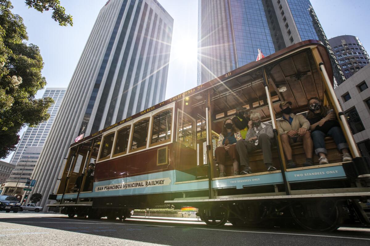 Visitors ride a cable car in San Francisco