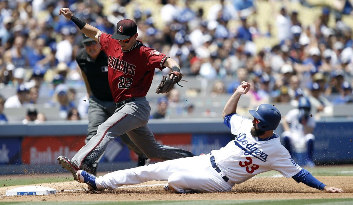 Arizona Diamondbacks third baseman Jake Lamb (22) races to beat the Dodgers' Scott Van Slyke to third for the force out during the first inning Sunday.
