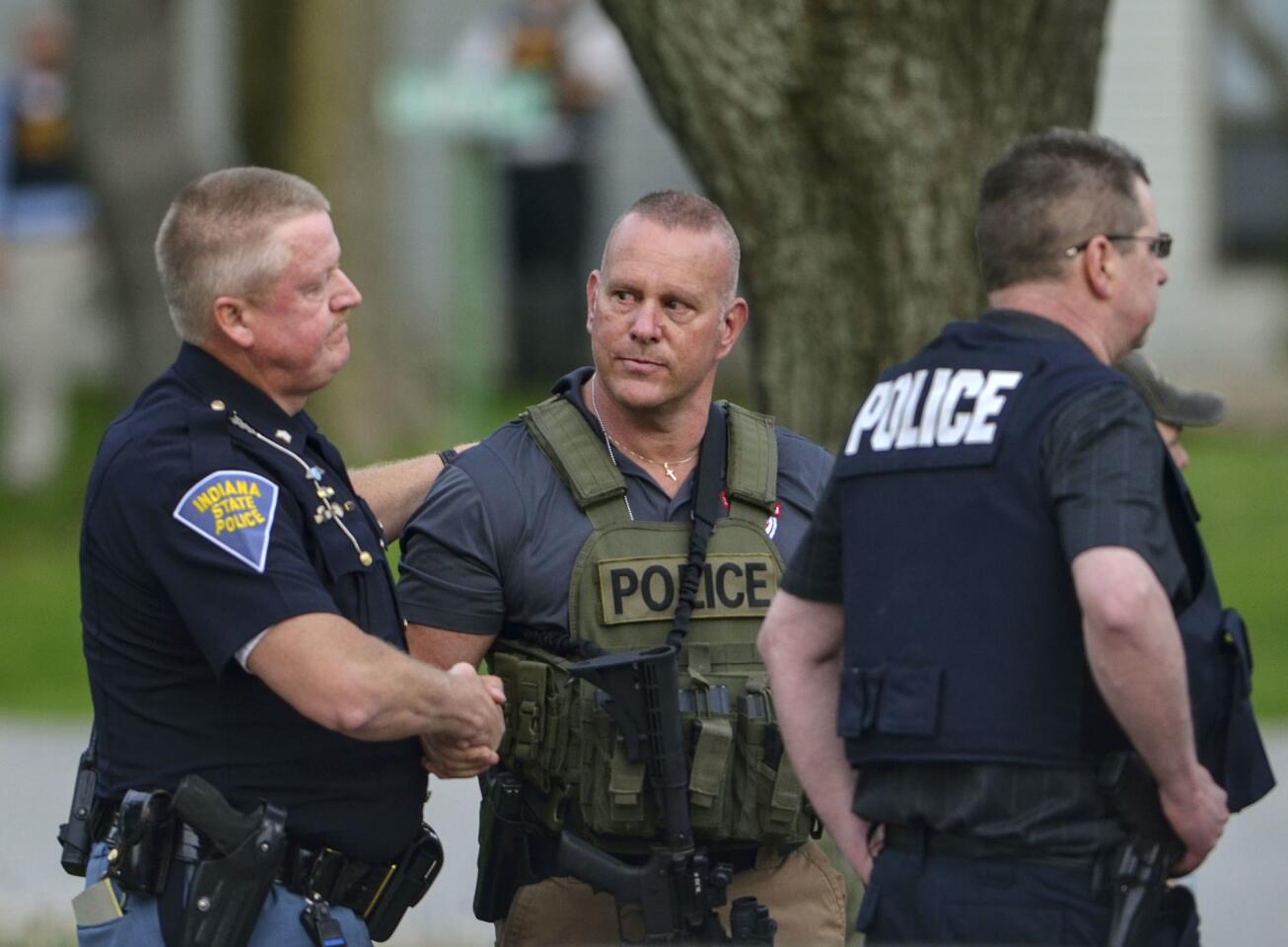 Indiana State Police Sgt. Joe Watts, left, consoles Terre Haute Chief of Police John Plasse, center, at the scene of a fatal shooting of a Terre Haute police officer at an apartment building May 4, 2018, in Terre Haute, Ind.