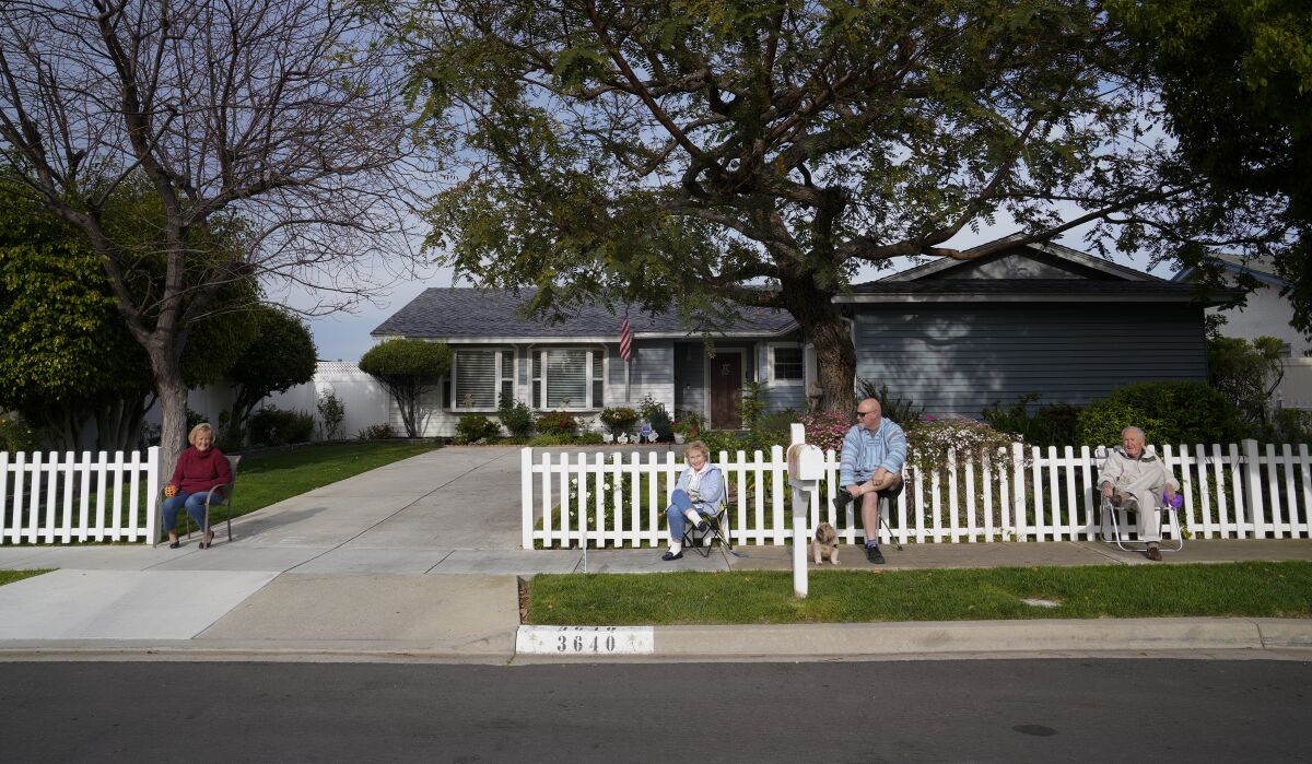 Kelly Gaglione, left, and her next-door neighbors, Suzanne Stelmach, Dave Stelmach and Allan Stelmach, enjoy sitting at the sidewalk in front of their home in Carlsbad. The neighbors on Trieste Drive gather once a week at the end of their driveway to enjoy a cocktail and a few laughs.