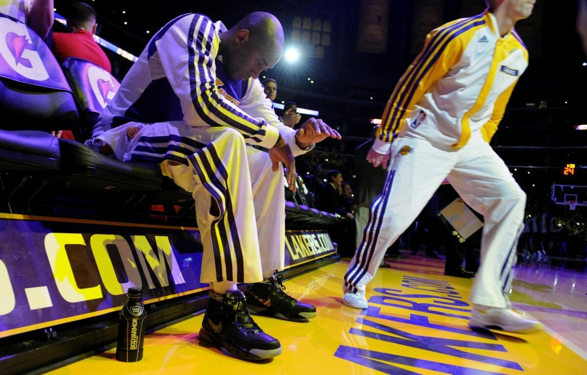 Lakers star Kobe Bryant sits on the bench as he's introduced before the start of Sunday's game against the Toronto Raptors. Bryant struggled in his return from a torn Achilles' tendon as the Lakers lost, 106-94.