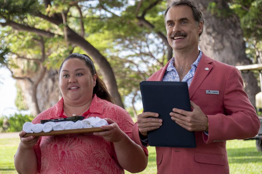 Two hotel staffers in pink uniforms waiting to greet guests