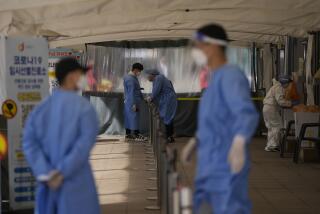 Health workers in protective gear prepare for visitors at a temporary screening clinic for the coronavirus in Seoul, South Korea, Monday, March 28, 2022. (AP Photo/Lee Jin-man)