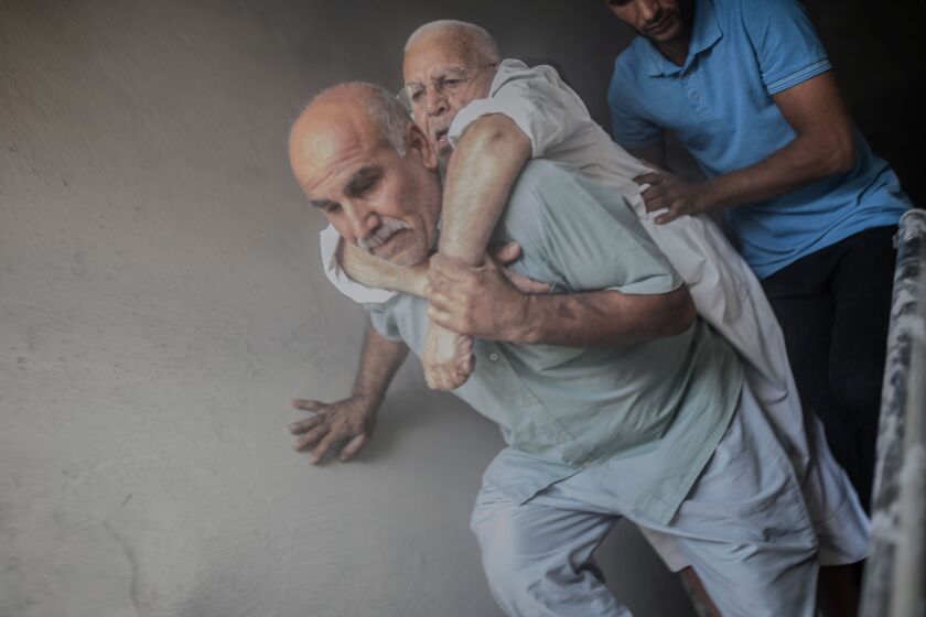 An elderly man is evacuated from a building in Akcakale, a town near the Turkish border with Syria, on Oct. 13 after it was hit by a rocket reported to be fired from within Syria.