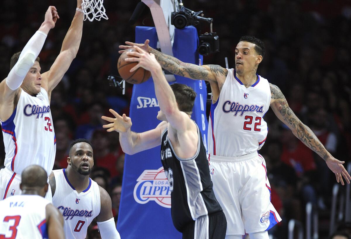 Spurs center Aron Baynes has his shot challenged by Clippers forwards Blake Griffin (32) and Matt Barnes (22) in Game 1 of their first-round playoff series on Sunday night at Staples Center.