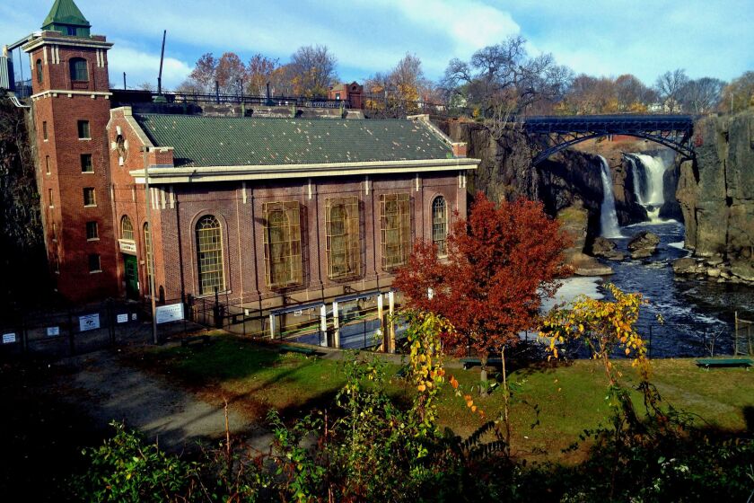 The Great Falls of Paterson, N.J., cascade beyond the SUM powerhouse, built in 1914 when hydroelectric power supplanted the extensive system of raceways and waterwheels that Alexander Hamilton helped envision to make Paterson - and America - great. PATERSON, NJ-- The Great Falls, with the 1914 S.U.M powerhouse in the foreground.