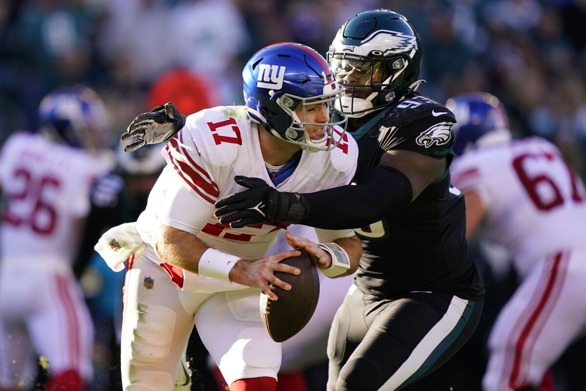 New York Giants' Jake Fromm, left, is tackled by Philadelphia Eagles' Milton Williams during the second half of an NFL football game, Sunday, Dec. 26, 2021, in Philadelphia. (AP Photo/Matt Rourke)