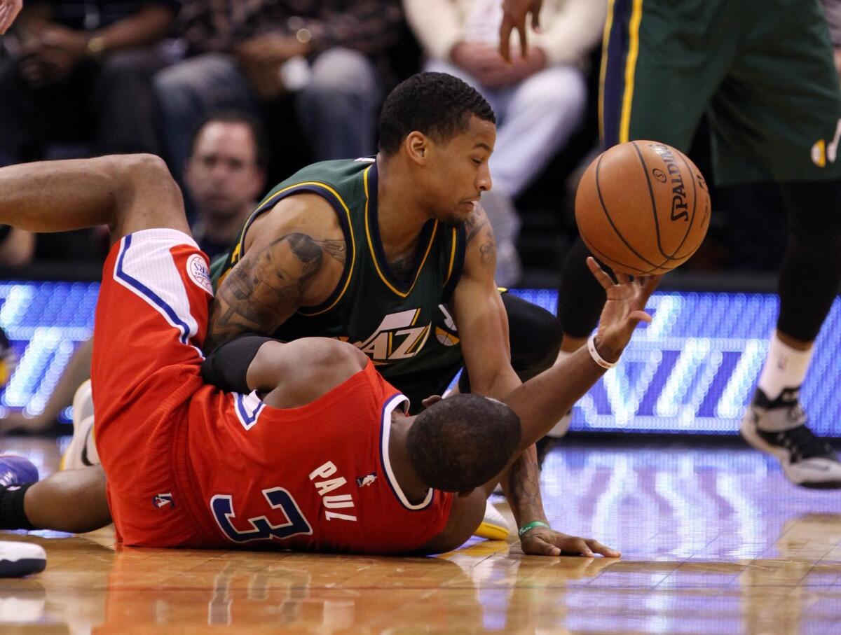 Chris Paul, bottom, battles for a loose ball with Utah's Trey Burke during the Clippers' 112-96 victory Saturday in Salt Lake City.