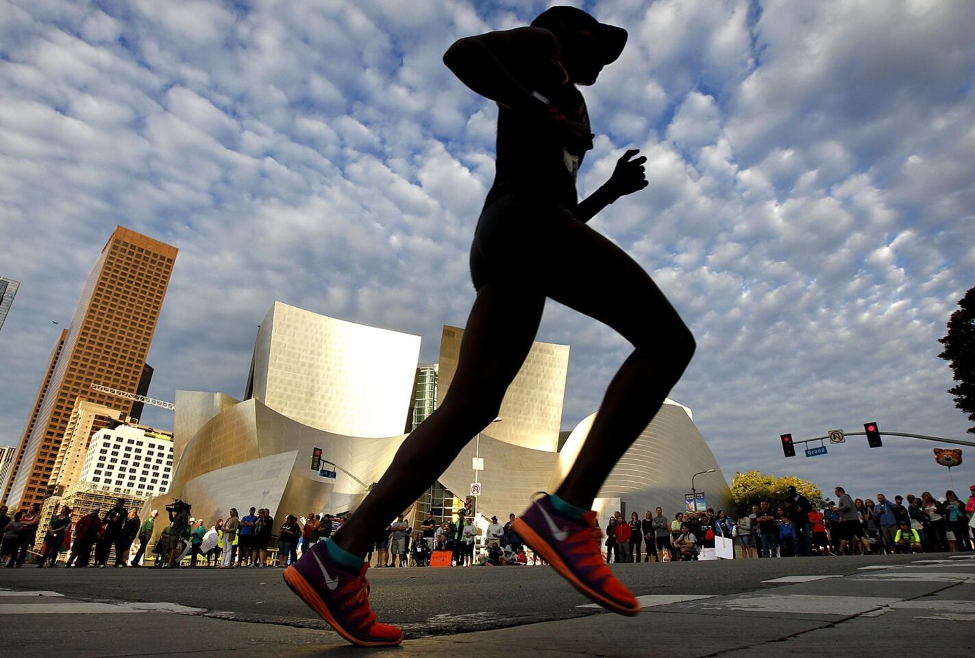 A runner passes Disney Hall in downtown Los Angeles during the L.A. Marathon.