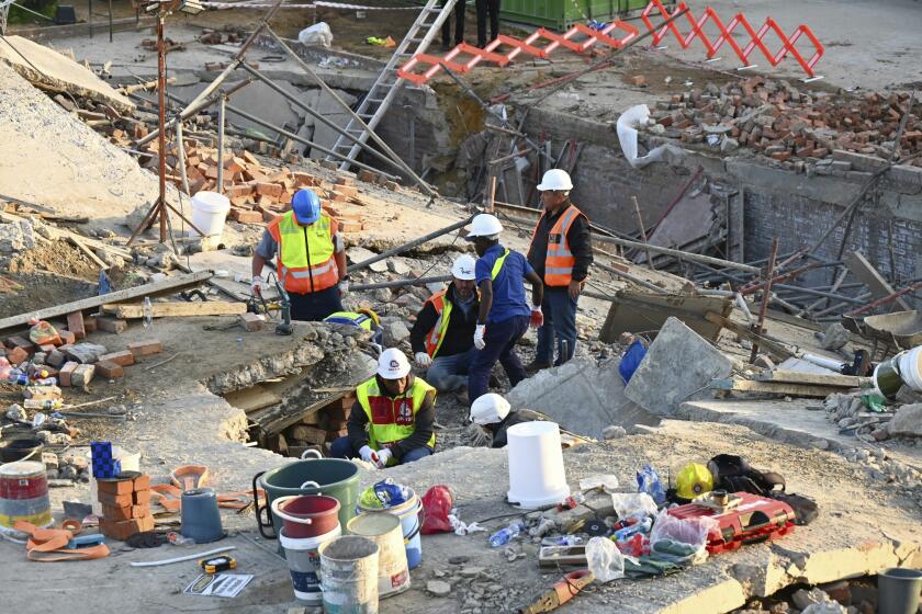 Trabajadores de emergencia en el lugar de un edificio derruido en George, Sudáfrica, el martes 7 de mayo de 2024. Al menos cinco obreros murieron y decenas seguían atrapados tras el derrumbe del edificio en construcción. (AP Foto)