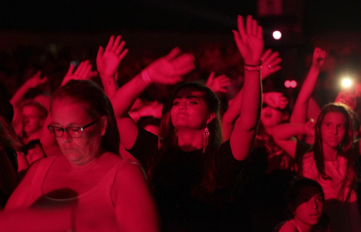 Fans sway their arms as they watch Nick Jonas perform.
