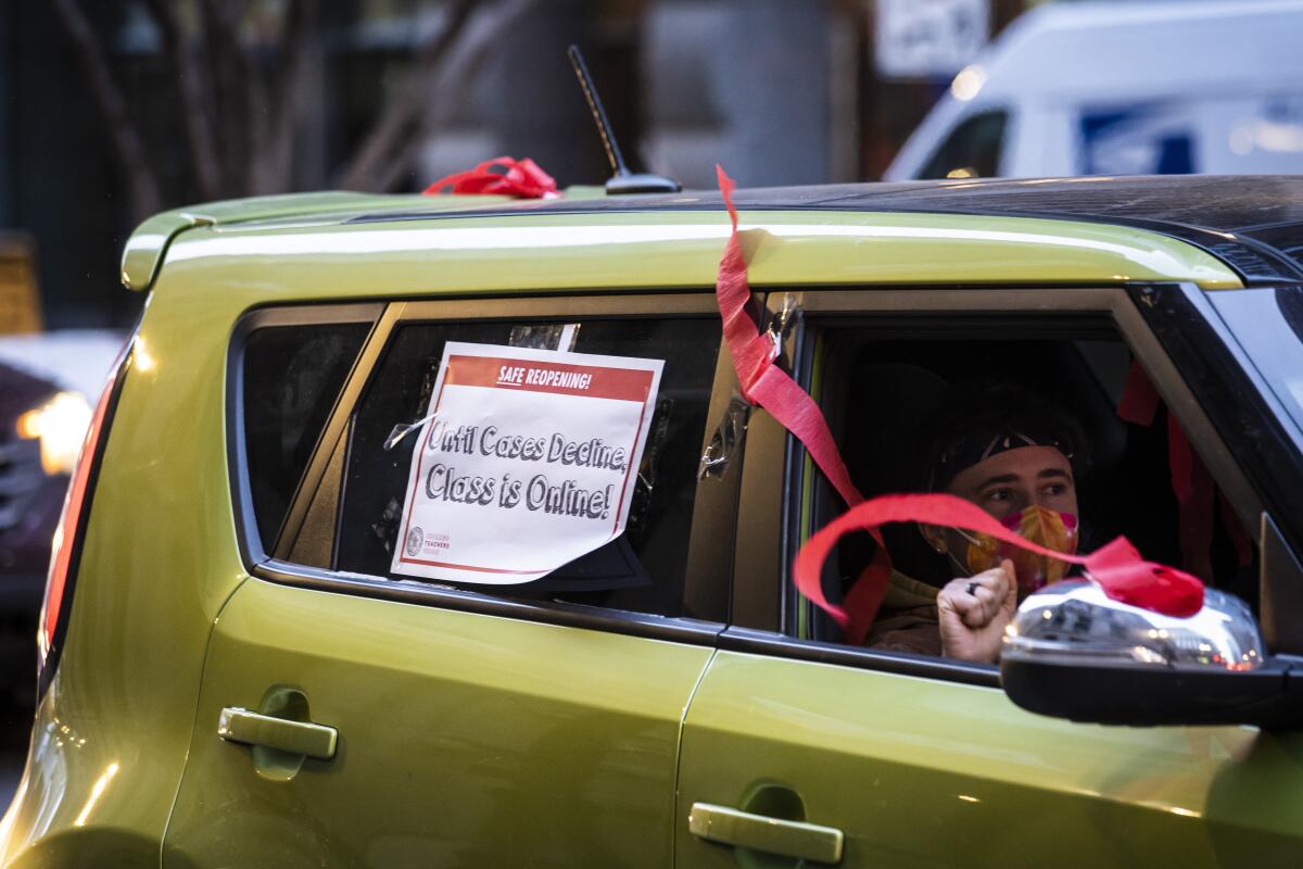 Person in car at caravan protest against Chicago school district