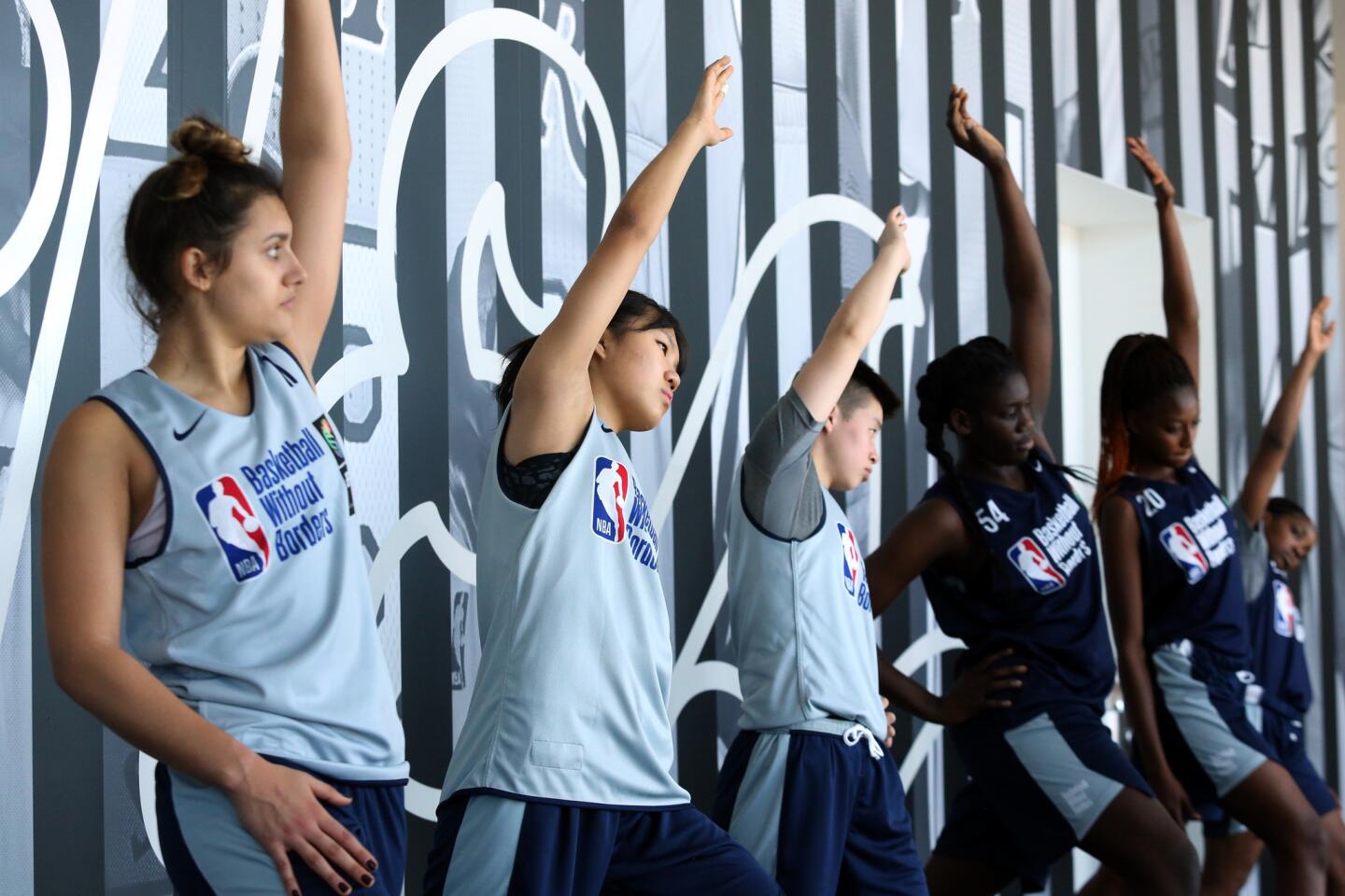 Girls stretch as they warm up for a training session at the Basketball Without Borders global camp.