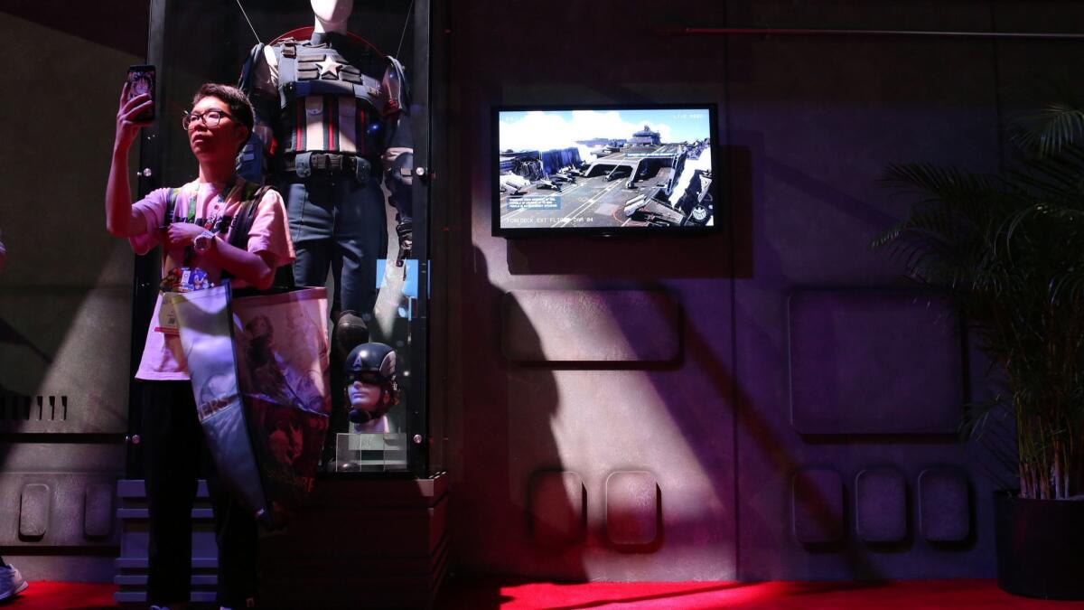 Jimmy Guan takes a picture in the Avengers booth during E3.