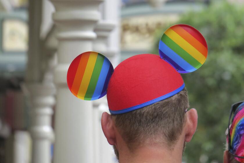FILE - A guest wears a Pride-themed Mickey Ears hat at the Magic Kingdom at Walt Disney World, in Lake Buena Vista, Fla., Saturday, June 3, 2023. Pride Month starts Saturday, June 1, 2024, across the U.S. and the globe, an annual celebration of LGBTQ+ people and culture. The main events are parades and festivals held in cities large and small. (Joe Burbank/Orlando Sentinel via AP, File)