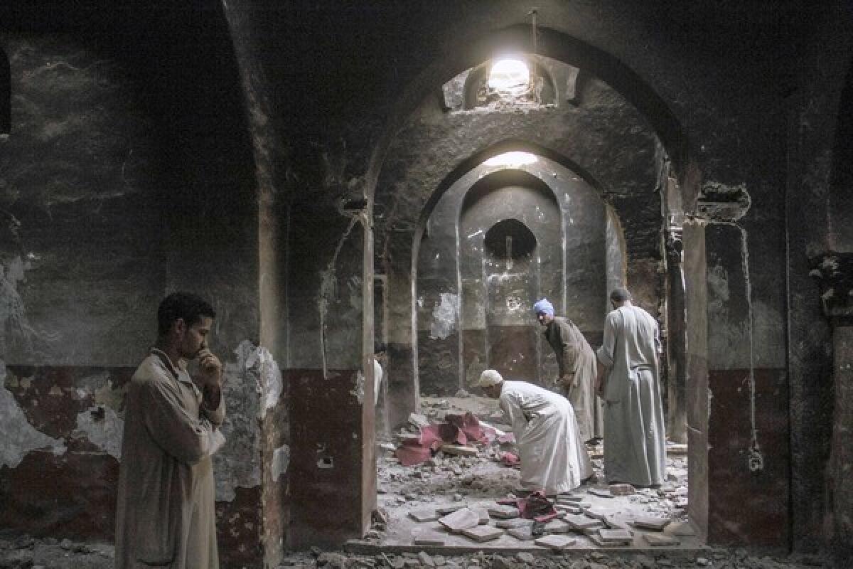 Villagers clean up the chapel in a monastery that was looted and burned by Islamists in Dalga, Egypt, on Sept. 3. Security forces on Monday swept into the town, making arrests and seizing weapons caches in an offensive targeting Islamists.