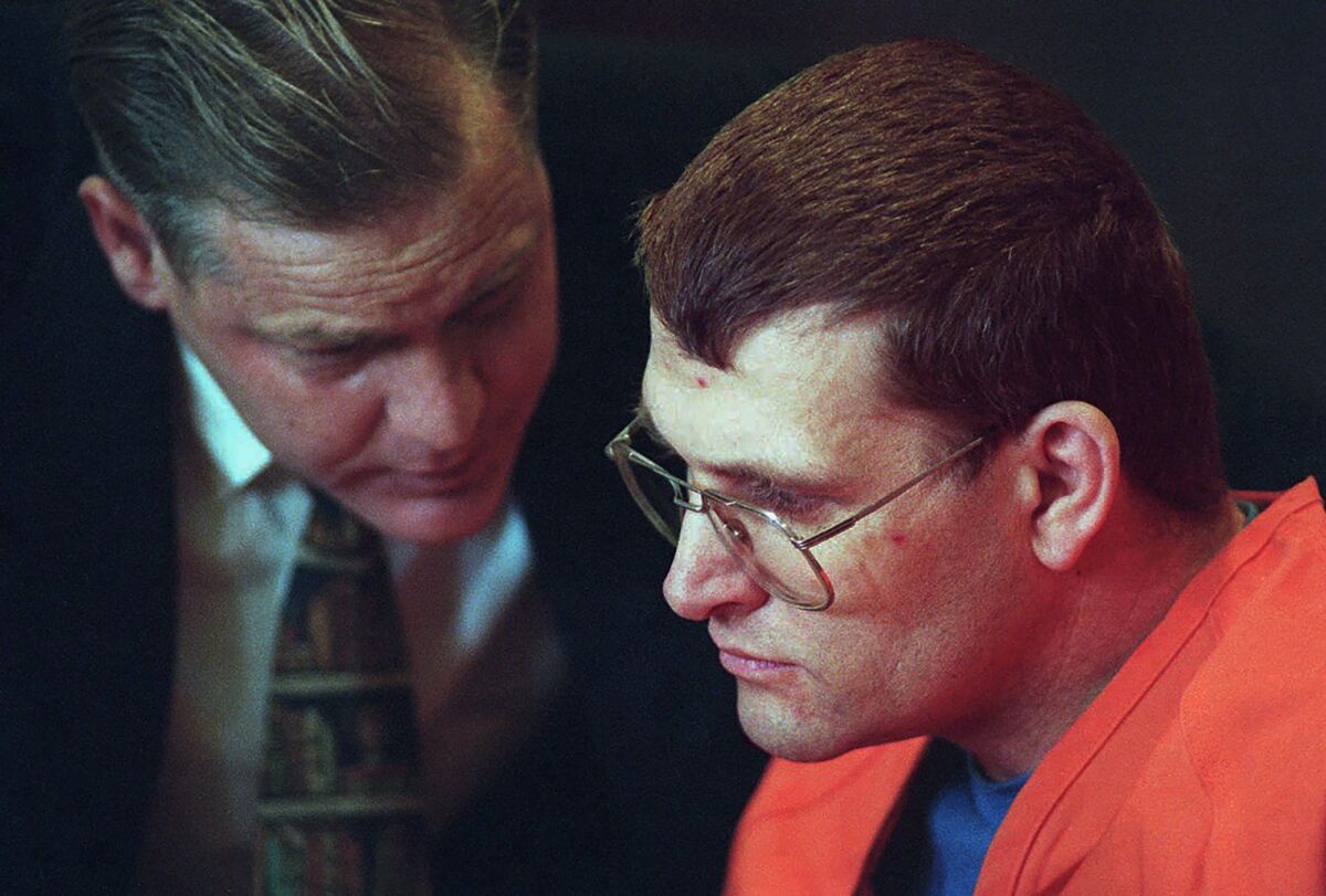 FILE - Accused murderer Keith Hunter Jesperson, dubbed the Happy Face Killer, right, listens to his attorney Tom Phelan, moments before pleading guilty to murder charges, Wednesday Oct. 18, 1995, at the Clark County Courthouse in Vancouver, Wash. A victim of the Happy Face Killer has been identified nearly 30 years after her body was left near a California highway. The Santa Clara County Sheriff's Office says genetic genealogy was used to match DNA to Patricia Skiple of Colton, Oregon. (Troy Wayrynen/The Columbian via AP, File)