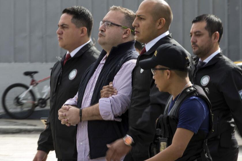 In this Monday, July 17, 2017 photo, Mexico's ex-governor of Veracruz state, Javier Duarte, is escorted in handcuffs by police to an aircraft as he is extradited to Mexico City, at an Air Force base in Guatemala City. The former governor, who went missing a few weeks after resigning his post in 2016, was extradited from Guatemala to Mexico on Monday to face corruption charges. (AP Photo/Moises Castillo)
