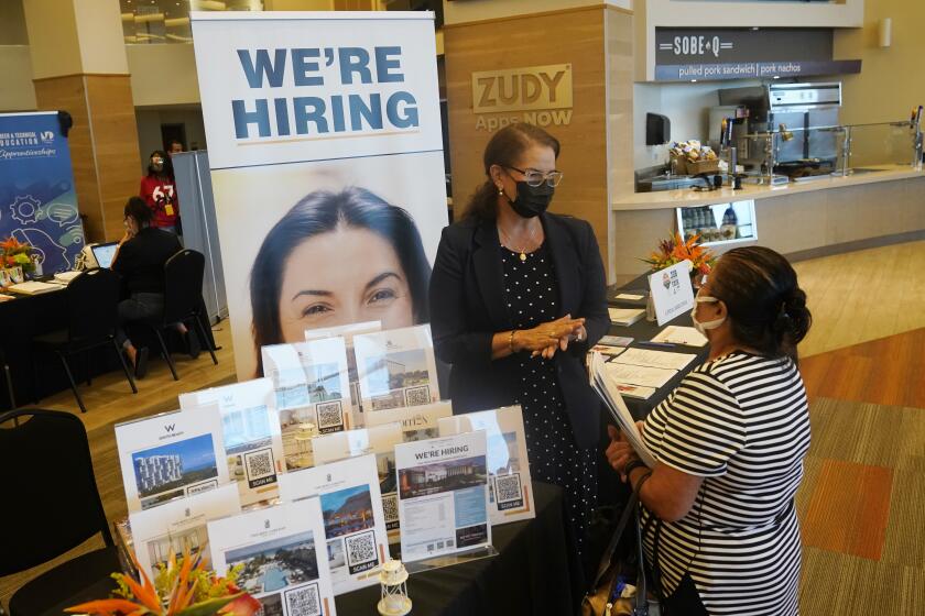 FILE - Marriott human resources recruiter Mariela Cuevas, left, talks to Lisbet Oliveros, during a job fair at Hard Rock Stadium, Friday, Sept. 3, 2021, in Miami Gardens, Fla. Last month, U.S. employers might have shed jobs for the first time in about a year, potentially raising alarms about the economy’s trajectory. Yet even if the January employment report coming Friday, Feb. 3, 2022, were to show a deep loss of jobs, there would be little mystery about the likely culprit: A wave of omicron wave of infections that led millions of workers to stay home sick, discouraged consumers from venturing out to spend and likely froze hiring at many companies — even those that want to fill jobs. (AP Photo/Marta Lavandier, File)