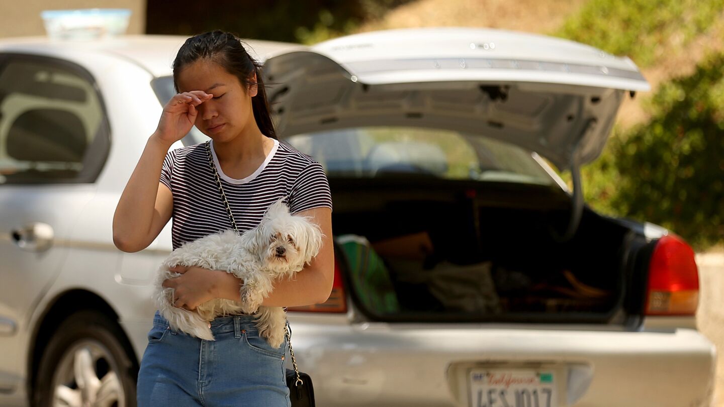 Connie Tran, 17, holds her dog Snowball as she prepares to evacuate her house on Las Lomas Road.