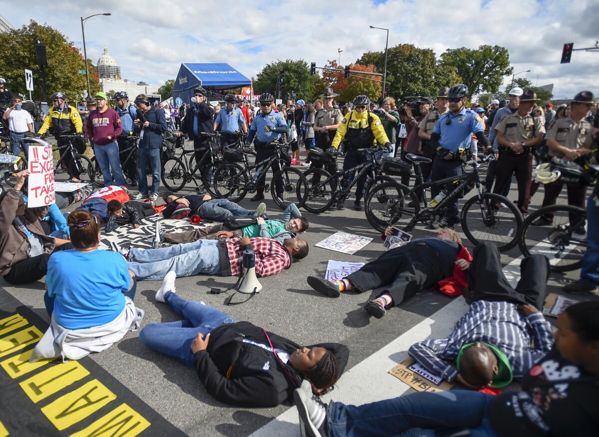Police officers use bikes to block protesters as supporters of the Black Lives Matter group hold a "die-in" near the finish area of the Medtronic Twin Cities Marathon in St. Paul, Minn., on Oct. 4.