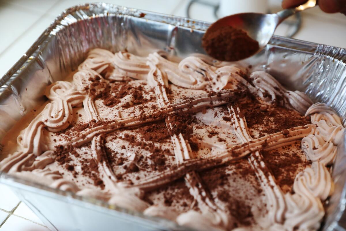 Giovanni Bolla puts the finishing touch on a tiramisu at his daughter's home in Encino.