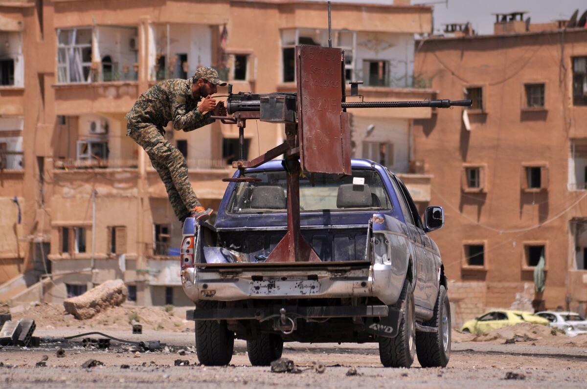 A member of the Kurdish People's Protection Units mans a machine gun in the Nashwa neighborhood in the northeastern Syrian province of Hasakeh on Sunday.