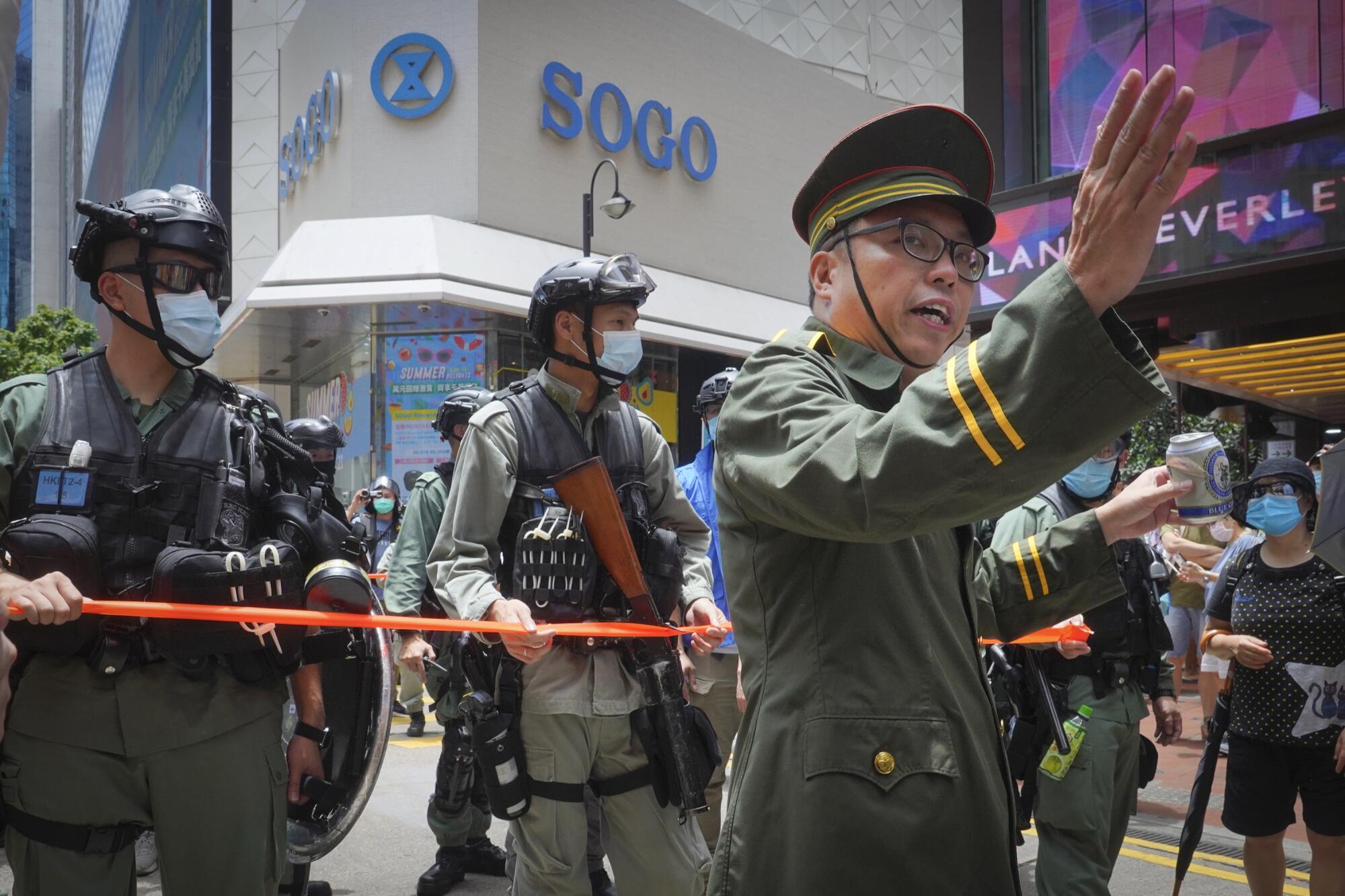 A protester, right, dressed as a Chinese official gestures during a demonstration in Causeway Bay 